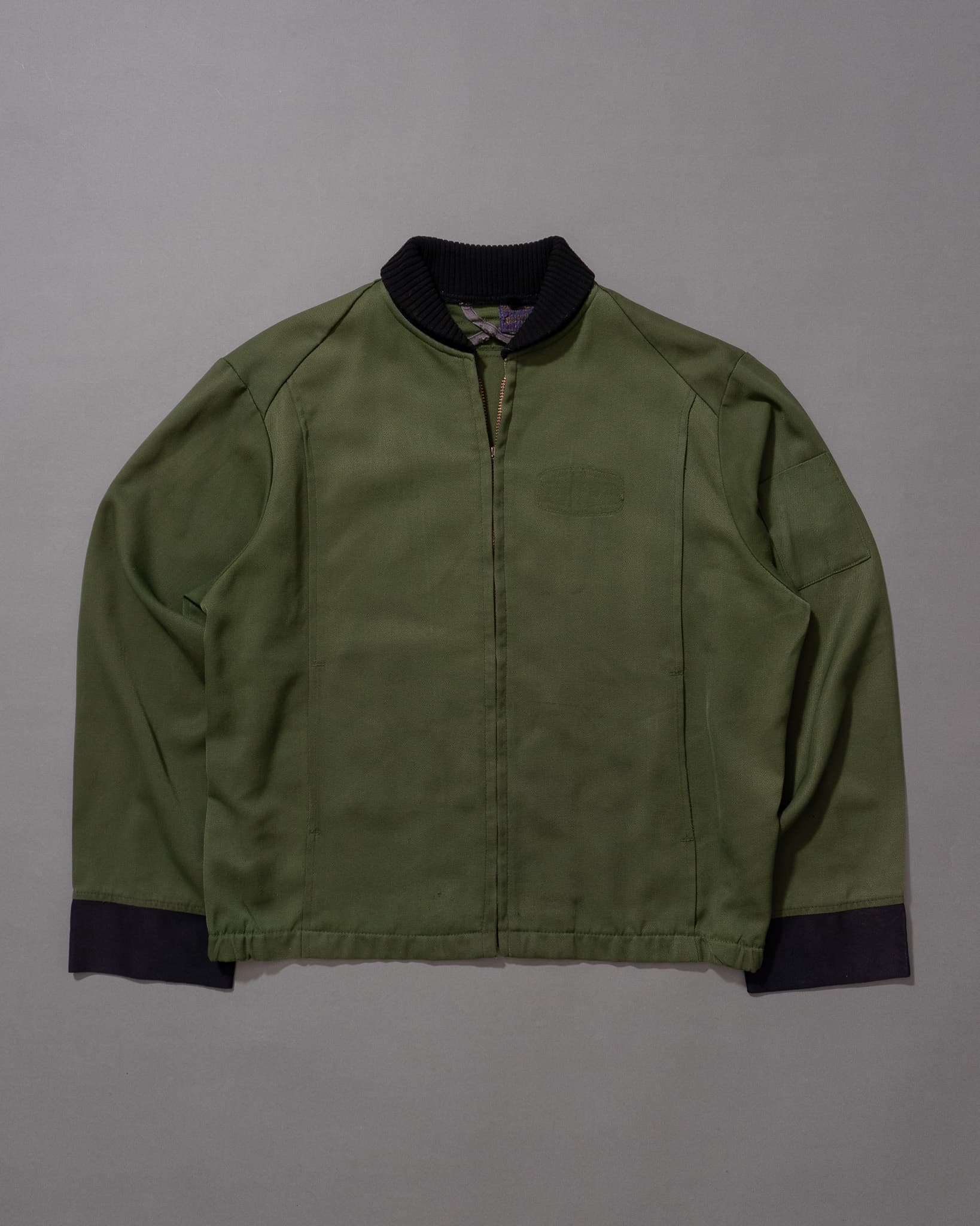 A green bomber jacket laid flat, auto-measured by Agora